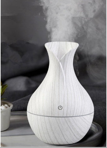 Humidificador ultrassónico branco em forma de vaso com vapor visível em ambiente de quarto relaxante